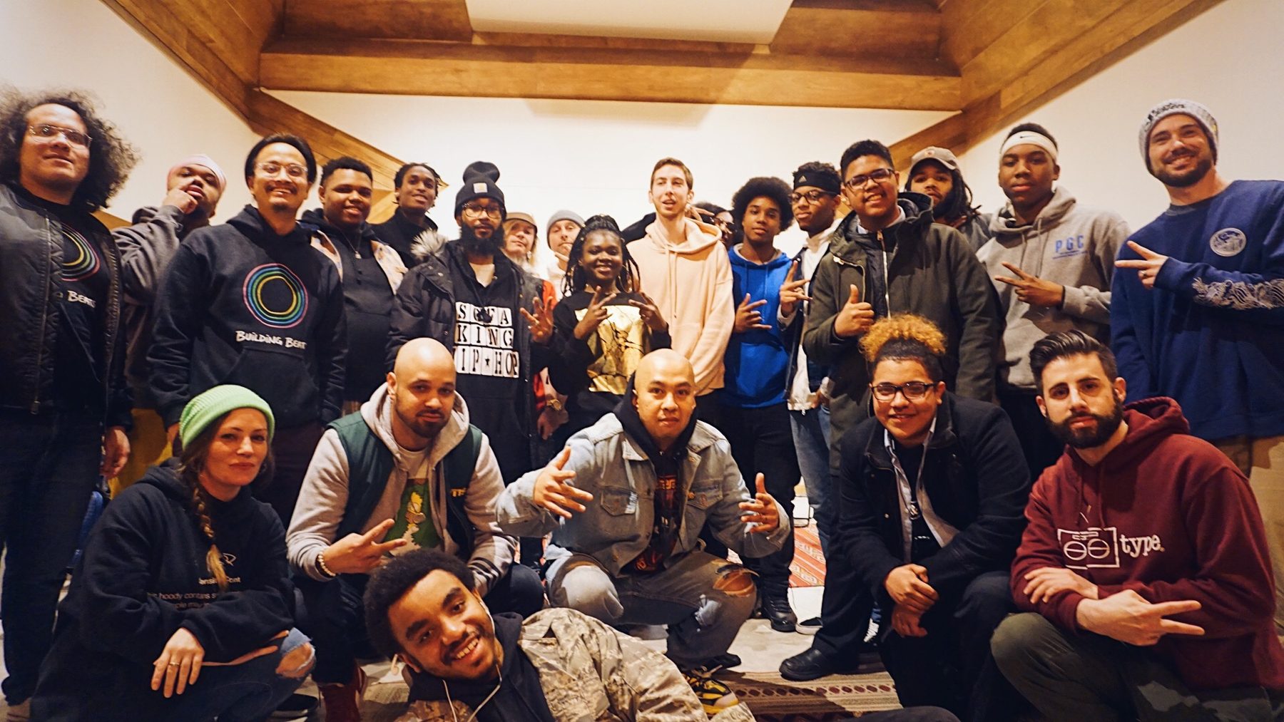 About thirty people in Building Beats hoodies posing as a group